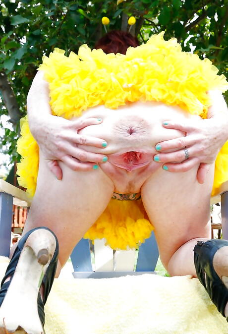 Hot red-haired mature Dirty Garden Girl in fancy skirt exhibiting her ass and jerking off outside